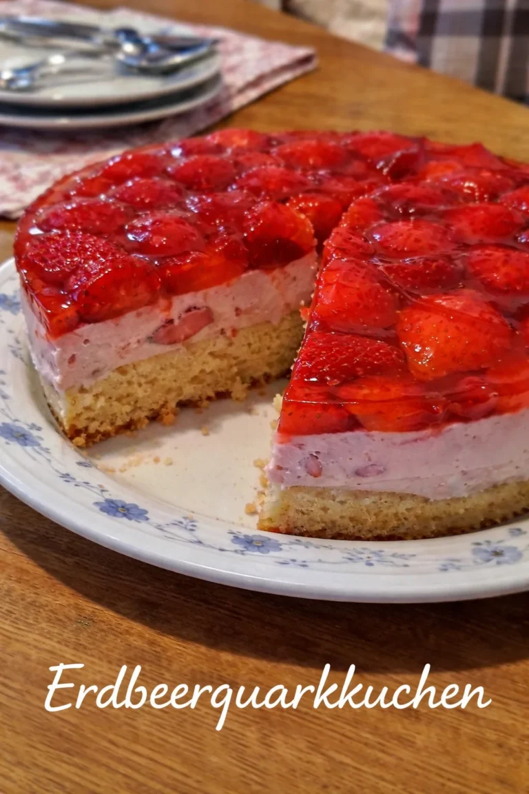 Erdbeerquarkkuchen auf einem Teller, dekoriert mit frischen Erdbeeren.