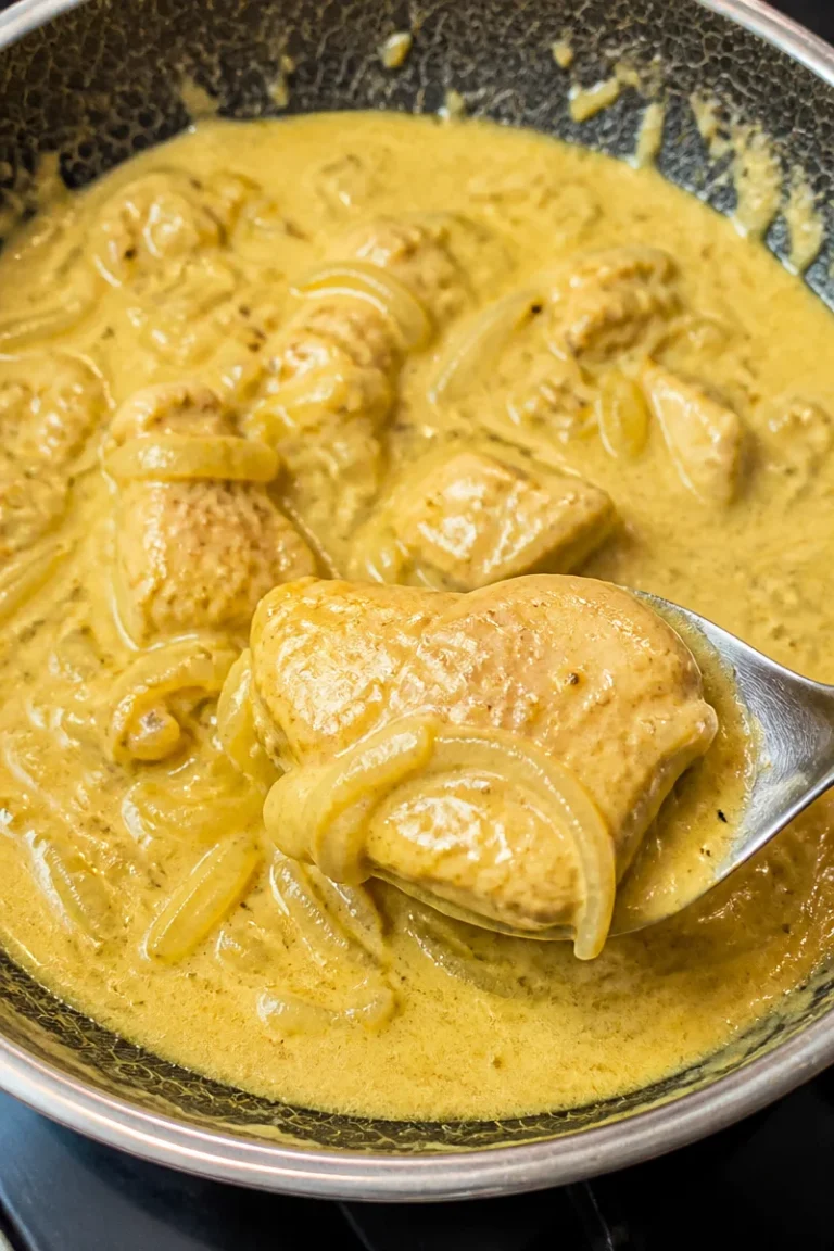 Zartes Hähnchen in cremiger Zwiebel-Sahnesoße auf einem Teller angerichtet